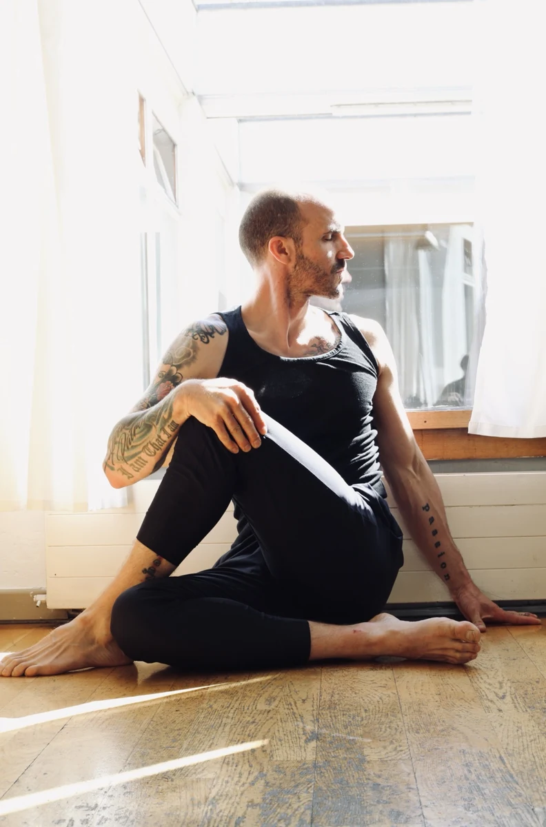 Will pratiquant une torsion assise de yoga dans une lumière naturelle chaleureuse